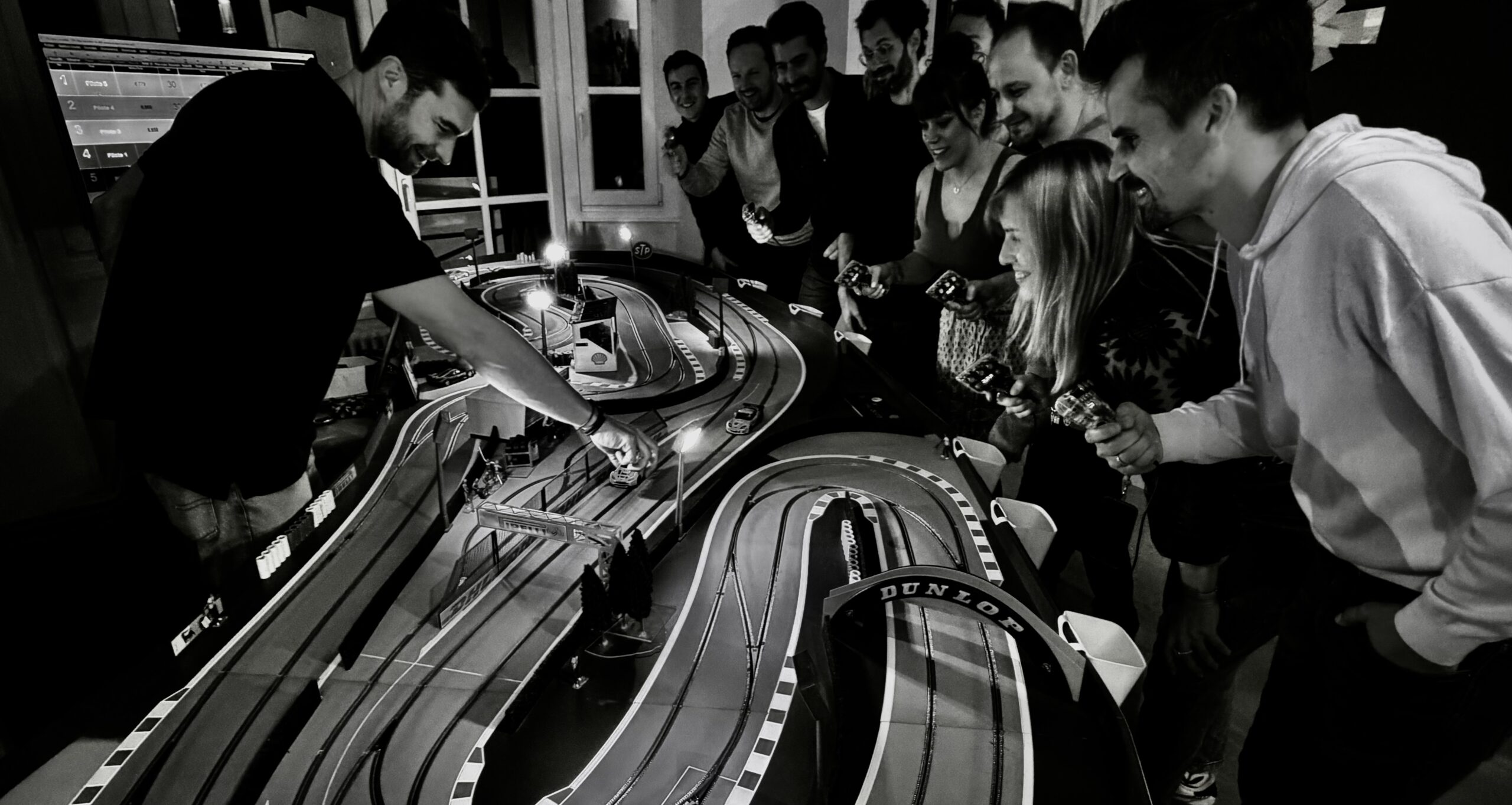 Groupe de collaborateurs en afterwork d'entreprise autour du circuit miniature électrique Good Time Racing - animation soirée originale