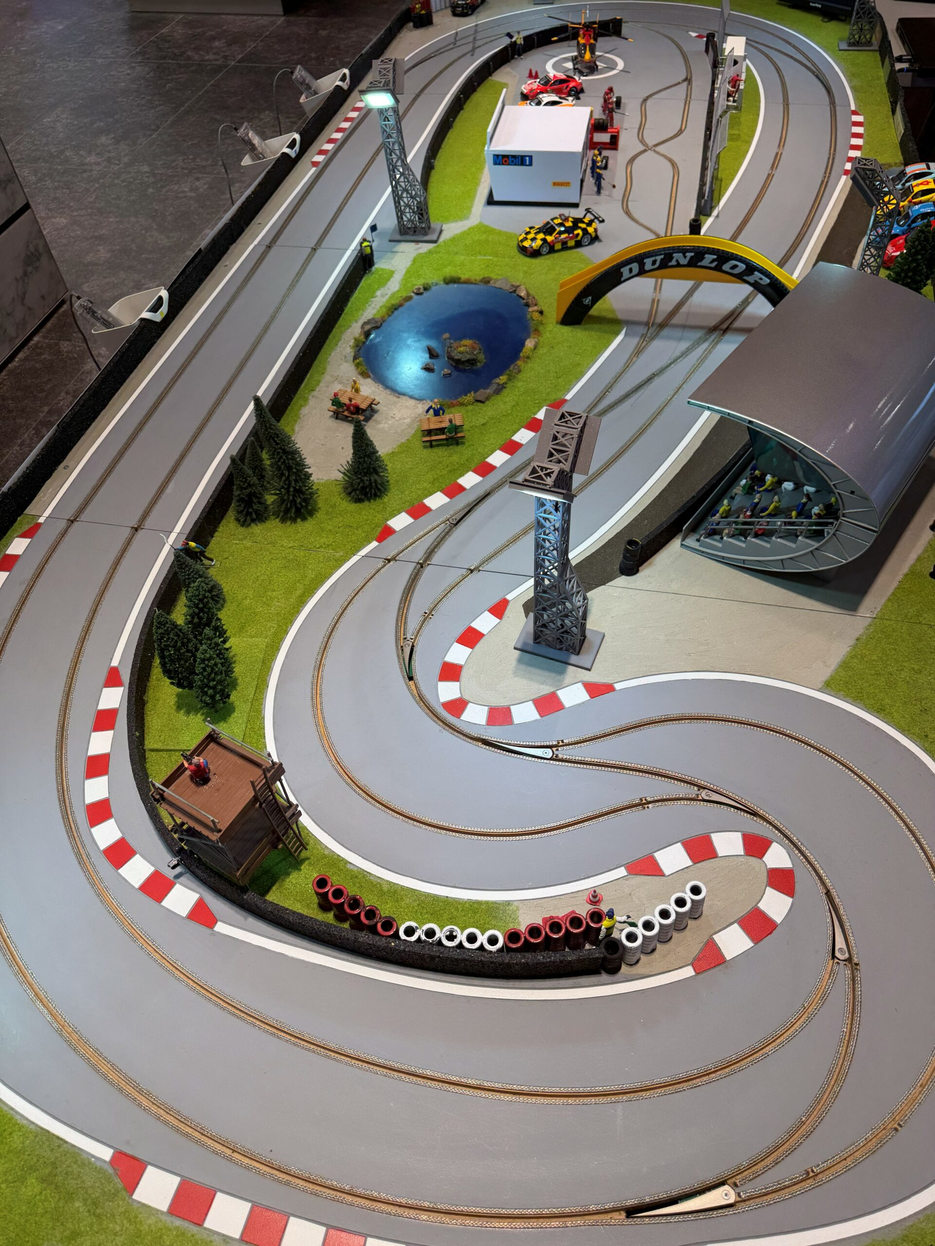 Vue plongeante sur le tracé sinueux du petit circuit, avec tribune, arche et stands